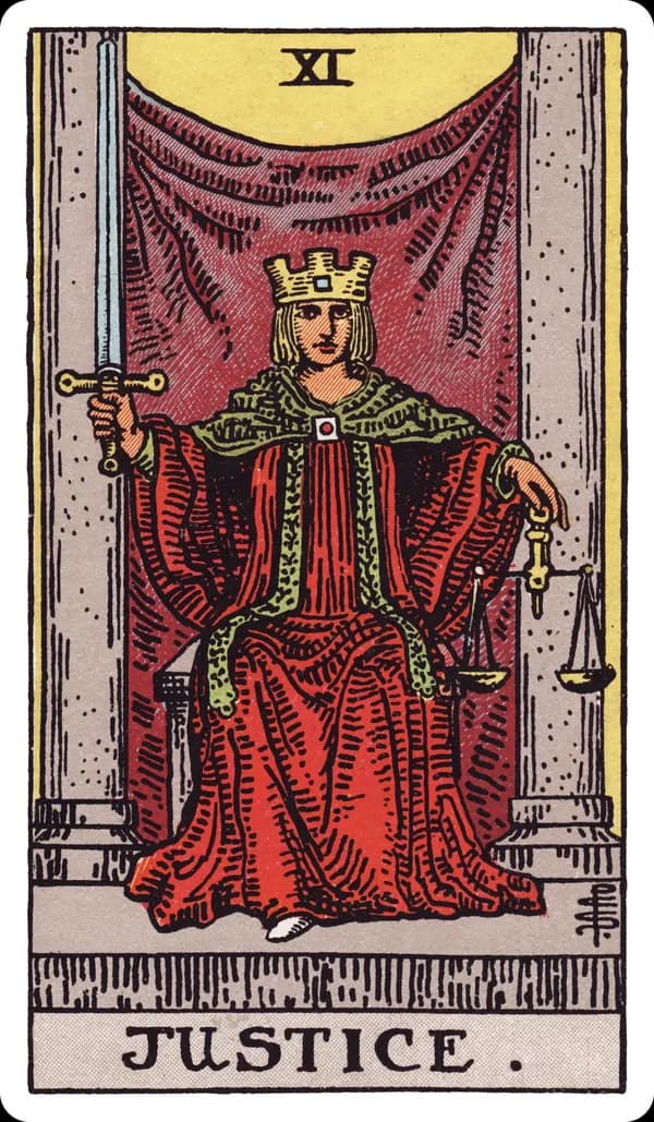 Justice from the Rider-Waite-Smith deck: a crowned figure in a red robe sits enthroned between two grey pillars, holding an upright double-edged sword in the right hand and a set of balanced scales in the left, a square clasp fastening the robe at the throat.