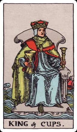 The King of Cups from the Rider-Waite-Smith deck: a king sits on a stone throne that appears to float on a choppy open sea, holding a scepter and a large golden cup, a fish-shaped amulet around his neck; a ship tosses in rough water to one side, and a fish leaps from the waves to the other.