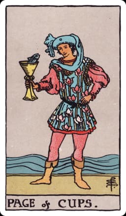 The Page of Cups from the Rider-Waite-Smith deck: a young figure in a flowing, flower-patterned tunic stands at the water's edge, holding up a golden cup from which a fish pops its head out; the figure gazes at the fish with open curiosity, waves rolling gently behind.