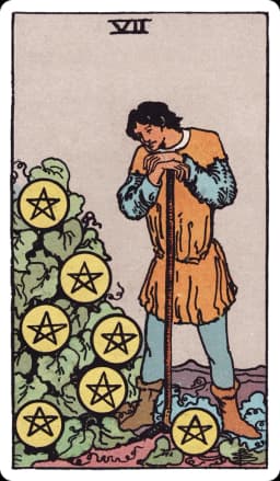 The Seven of Pentacles from the Rider-Waite-Smith deck: a farmer leans on his hoe, pausing to study a leafy bush heavy with seven gold pentacles growing on it like fruit, a distant field and hills visible behind him.