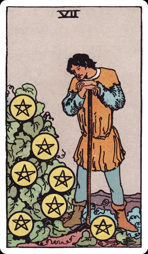 The Seven of Pentacles from the Rider-Waite-Smith deck: a farmer leans on his hoe, pausing to study a leafy bush heavy with seven gold pentacles growing on it like fruit, a distant field and hills visible behind him.