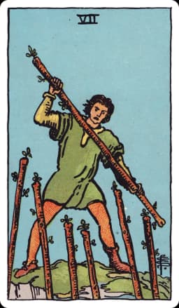 The Seven of Wands from the Rider-Waite-Smith deck: a young man stands on uneven, elevated rocky ground gripping a wand and swinging it down defensively at six other wands jabbing up at him from below, one of his boots mismatched with the other.