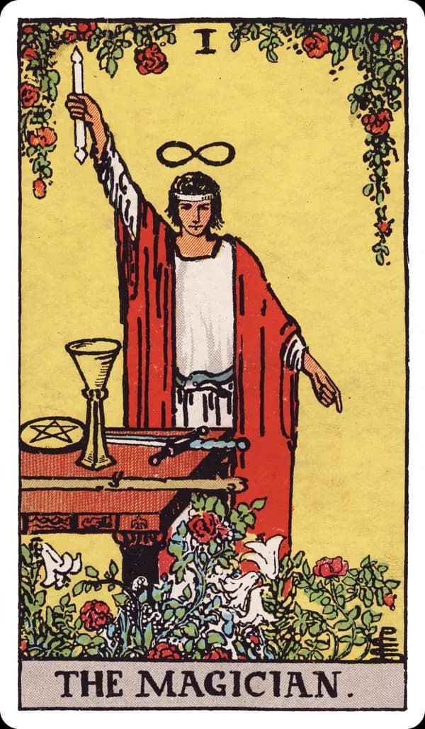 The Magician from the Rider-Waite-Smith deck: a young man in a white robe under a red cloak stands behind a table, right arm raised holding a wand toward the sky, left hand pointing down toward the earth, a lemniscate (infinity symbol) floating above his head, an ouroboros serpent belt at his waist, and a cup, pentacle, sword, and wand — the four Minor Arcana suit symbols — arranged on the table before him, with red roses and white lilies growing at his feet.