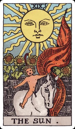 The Sun from the Rider-Waite-Smith deck: a radiant sun with a human face shines directly overhead, a naked child rides a white horse bareback beneath it, arms outstretched and a red banner streaming behind, four sunflowers bloom over a low garden wall in the background.