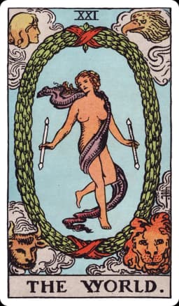 The World from the Rider-Waite-Smith deck: a lightly draped dancing figure holds a wand in each hand at the center of an oval laurel wreath bound top and bottom with red ribbon, her legs crossed at the shin; in the four corners outside the wreath, a winged human figure, an eagle, a bull, and a lion each look inward.