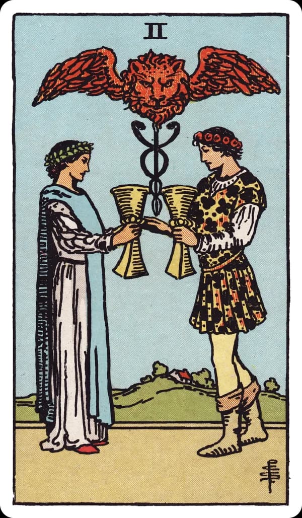 The Two of Cups from the Rider-Waite-Smith deck: a man and a woman face each other, each raising a cup toward the other in a mutual toast, crowned with laurel and flowers; between and above them a winged caduceus topped by a small lion's head rises from a grassy mound.
