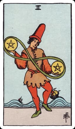 The Two of Pentacles from the Rider-Waite-Smith deck: a young figure in a jester-like cap dances on a shoreline, juggling two pentacles joined by a green ribbon looped into a lemniscate, while two ships ride large swelling waves in the background.